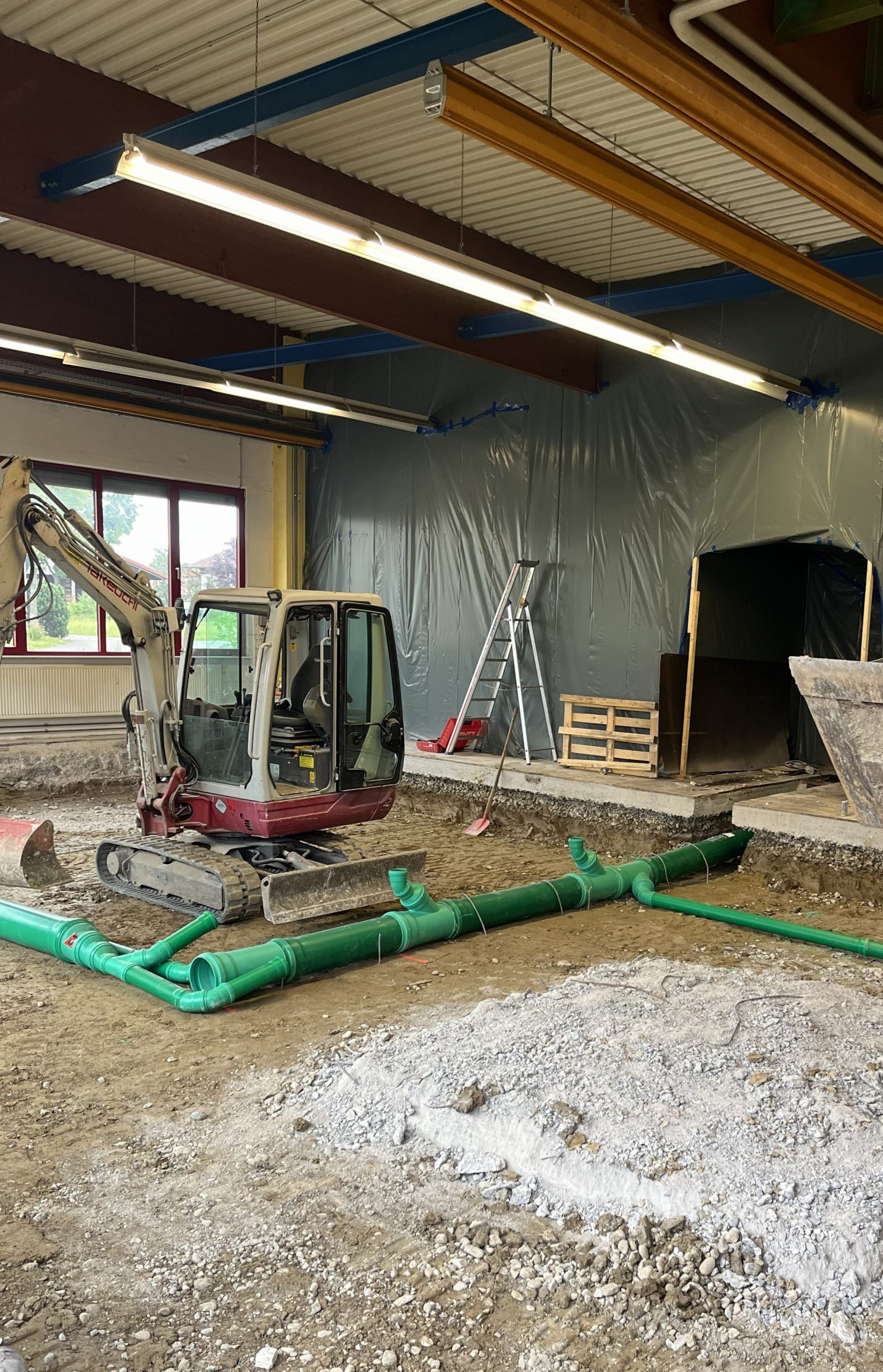 Takeuchi-TB-228-Minibagger bei Erdarbeiten in einer Halle